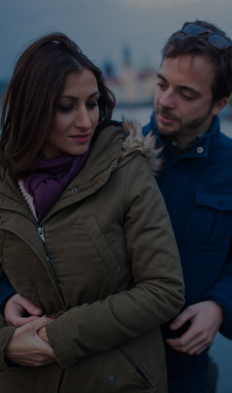 An unsure couple stands together for a photo.