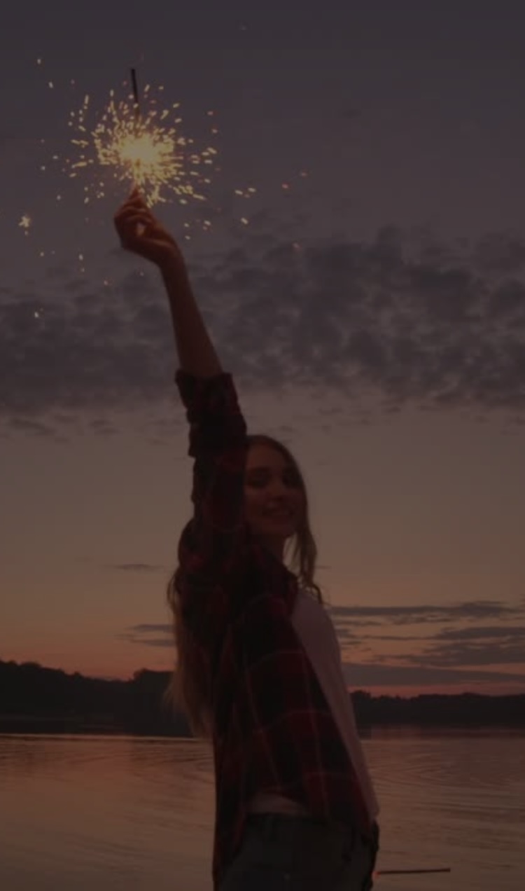 A girl celebrates with a sparkler during a summer party.