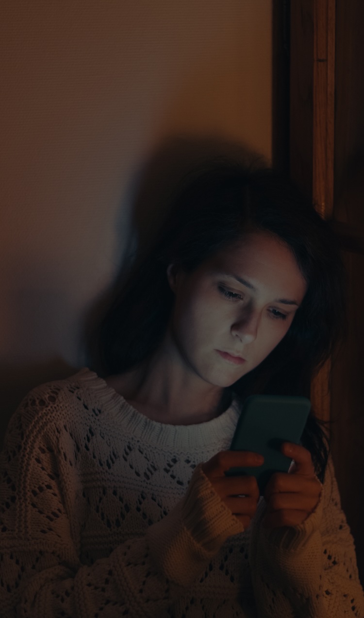 A woman texts a friend going through a mental health crisis while looking stressed out.