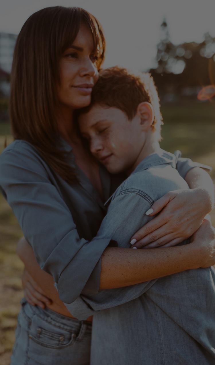 A mother holds her son in a hug.