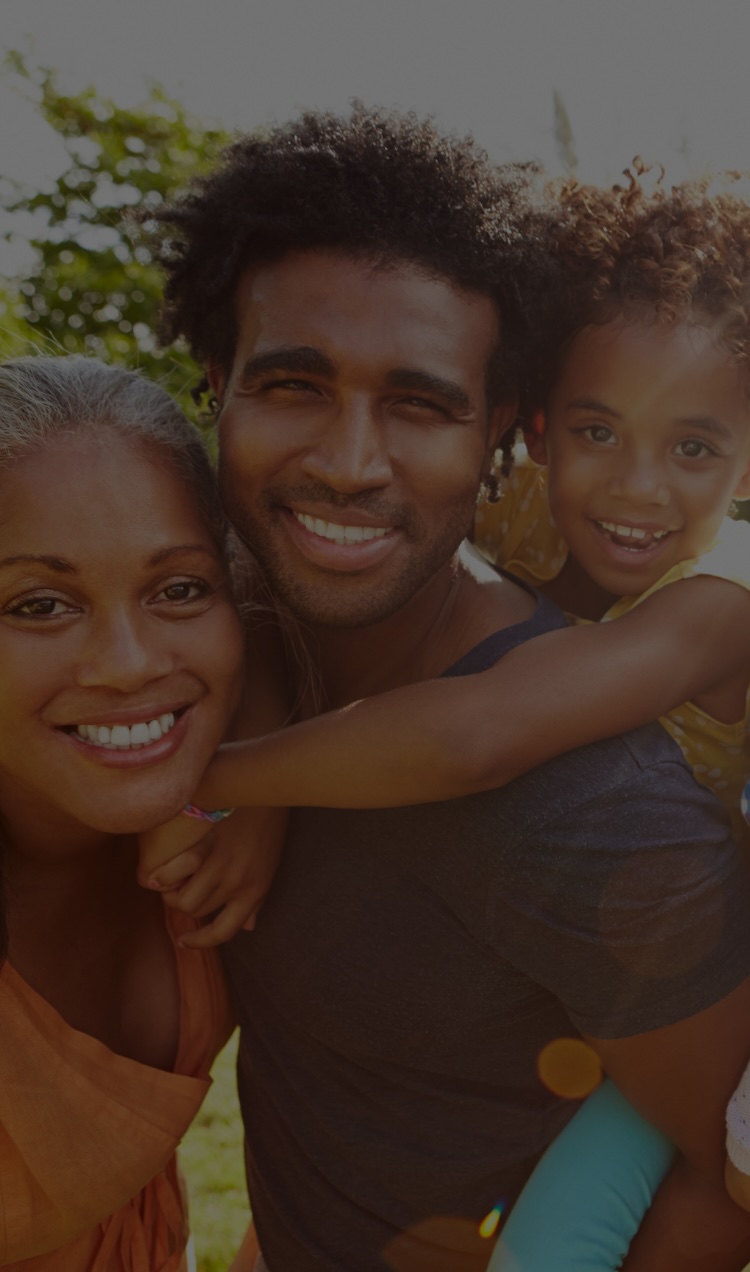 A close family with a grandmother, a son, and a granddaughter smiling together.