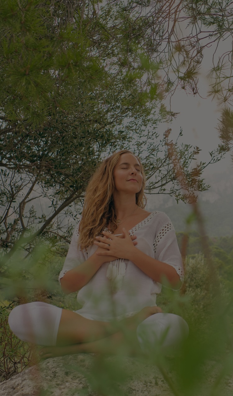 A woman meditates outside.